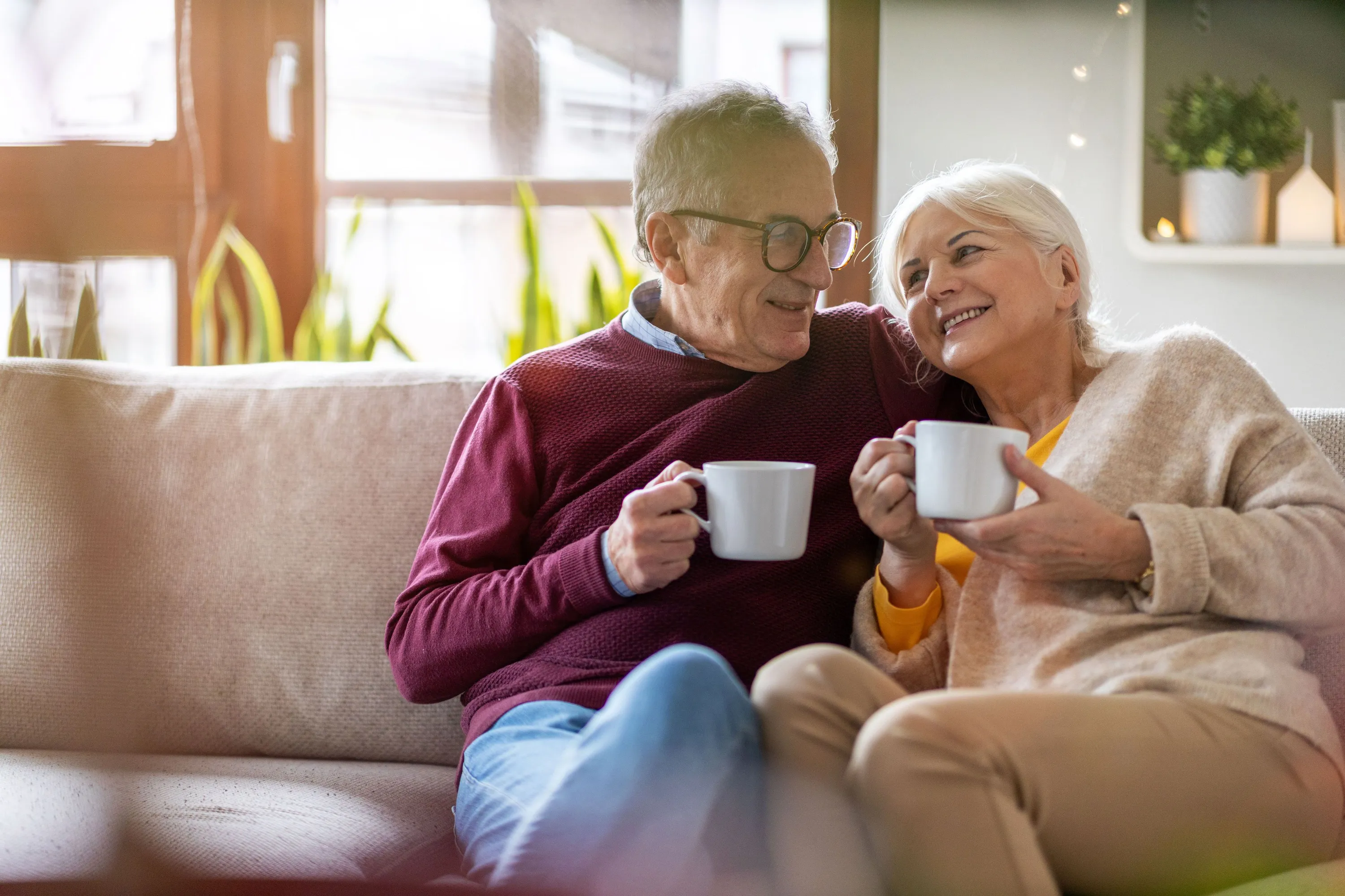 Couple smiling and sharing coffee at home